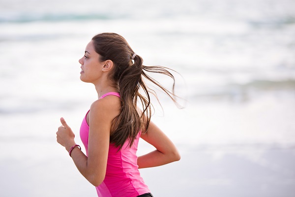 solo female runner jogging on the beach